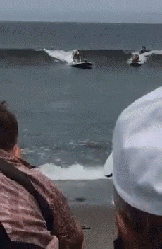 A Group Of People Are Watching Two Jet Skis Racing In The Ocean GIF