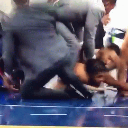 A Group Of People Are Wrestling On A Blue Wrestling Mat GIF