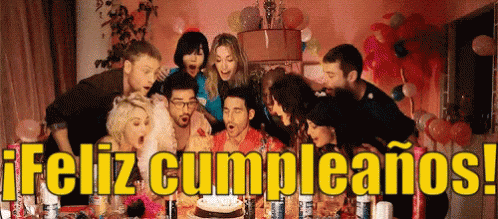 A Group Of People Blowing Out Candles On A Birthday Cake With The Words Feliz Cumpleanos In The Background GIF