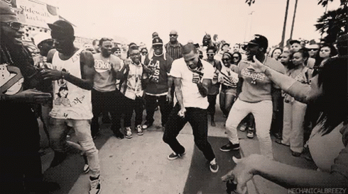 A Group Of People Dancing In Front Of A Sign That Says Mechanicalbreezezy GIF