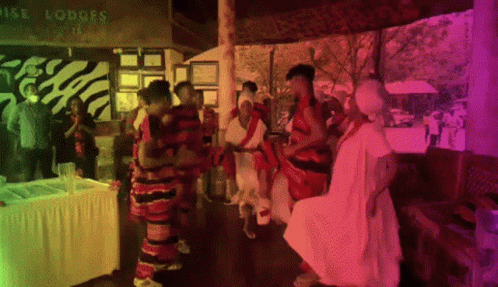 A Group Of People Dancing In Front Of A Sign That Says Royal Lodges GIF