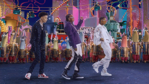A Group Of People Dancing In Front Of A Sign That Says Spongebob Squarepants GIF