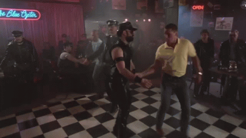 A Group Of People Dancing Under A Neon Sign That Says The Blue Pointer GIF