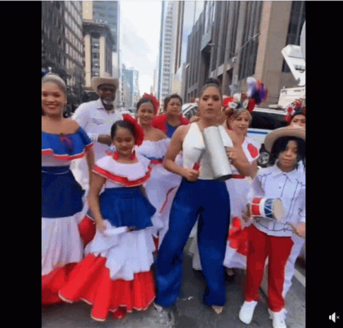 A Group Of People Dressed In Red White And Blue Standing On A Street GIF