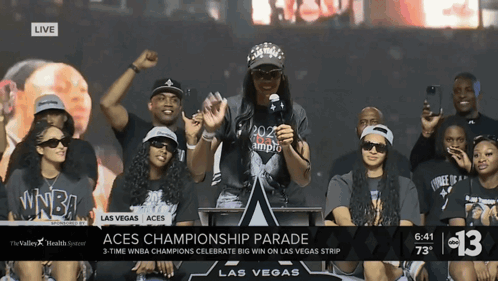 A Group Of People Gathered Around A Podium With The Words Aces Championship Parade On The Bottom GIF