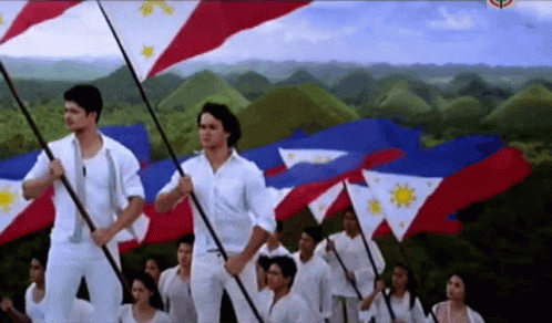 A Group Of People Holding Flags With A Mountain In The Background GIF