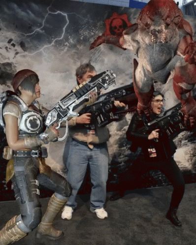 A Group Of People Holding Guns Standing In Front Of A Monster GIF