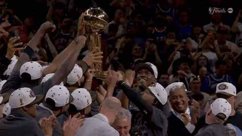 A Group Of People Holding Up A Trophy That Says Finals On The Bottom GIF