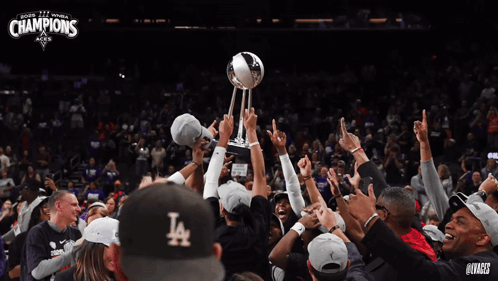 A Group Of People Holding Up A Trophy With The Word Champions On It GIF
