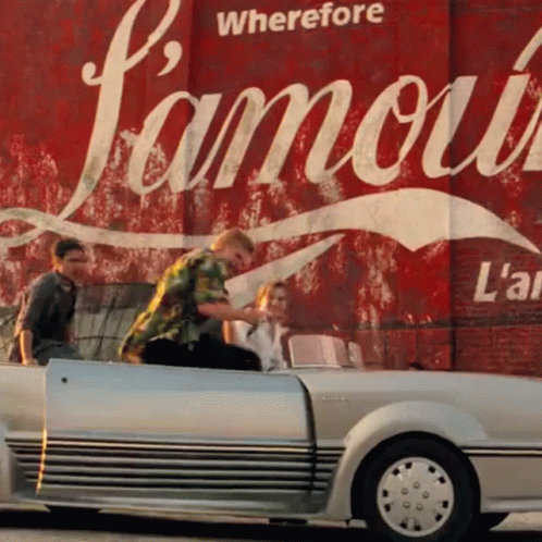 A Group Of People In A Car In Front Of A Sign That Says " Wherefore Famous " GIF
