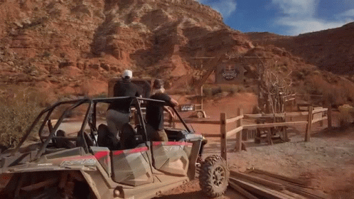 A Group Of People In A Polaris Atv In The Desert GIF