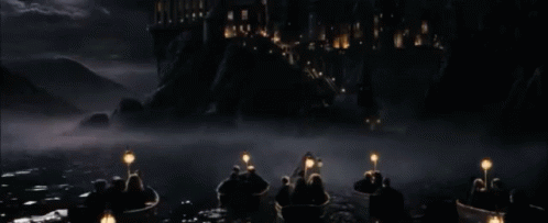 a group of people in boats with lanterns in the water in front of a castle