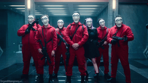 A Group Of People In Red Jumpsuits And Masks Holding Guns With The Words Dryedmangoes.com In The Corner GIF