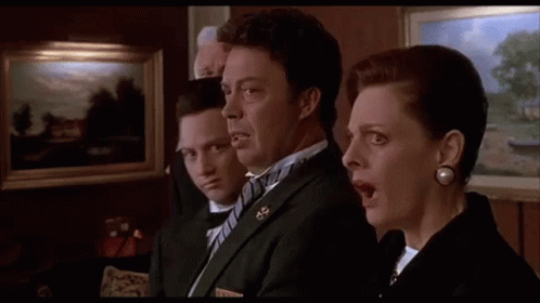 A Group Of People In Suits And Bow Ties Are Standing Next To Each Other In A Room With Their Mouths Open . GIF