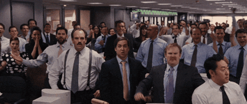 A Group Of People In Suits And Ties Are Dancing In A Room With A Sign That Says ' Equity ' On It GIF