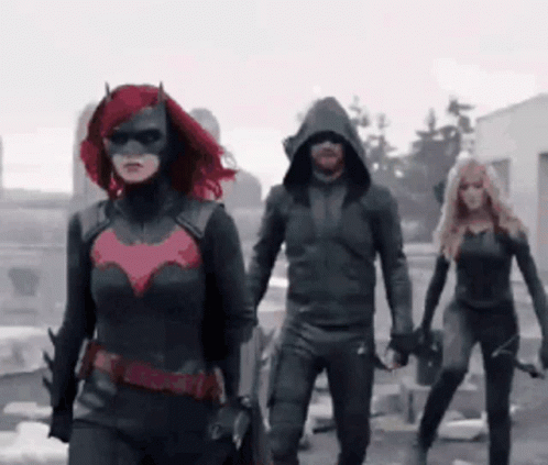 A Group Of People In Superhero Costumes Are Walking In A Line GIF