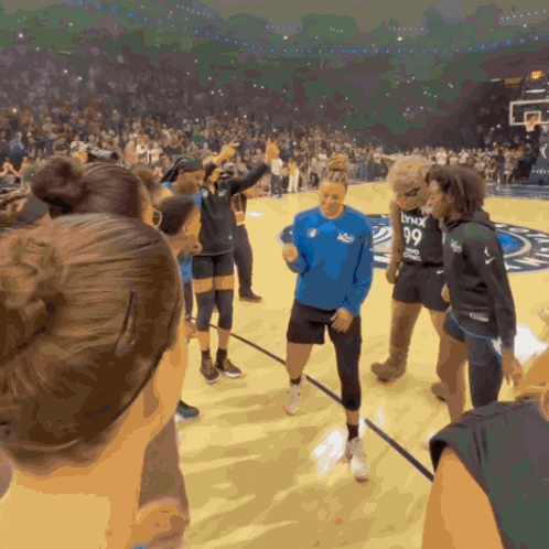 A Group Of People On A Basketball Court With A Mascot Wearing A Lynx 99 Jersey GIF