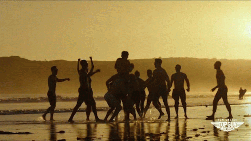 A Group Of People On A Beach With A Top Gun Logo On The Bottom GIF