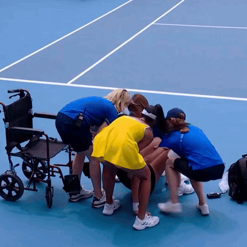 A Group Of People On A Tennis Court With A Wheelchair In The Foreground GIF