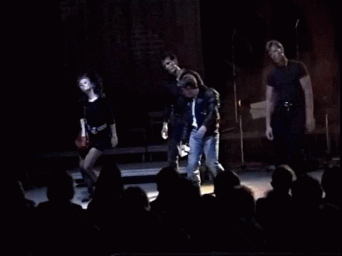 A Group Of People On Stage With The Words You 'Re Playin ' With Fire GIF