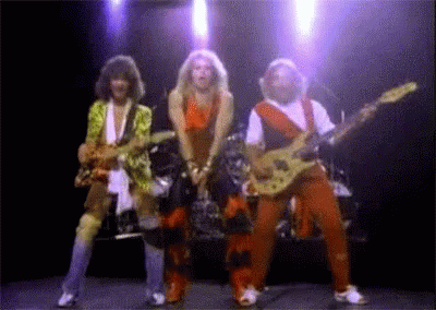 A Group Of People Playing Guitars On Stage GIF