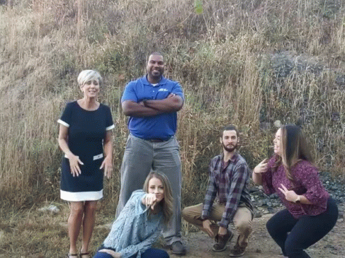 A Group Of People Posing For A Picture With One Man Wearing A Shirt That Says ' A & A ' GIF