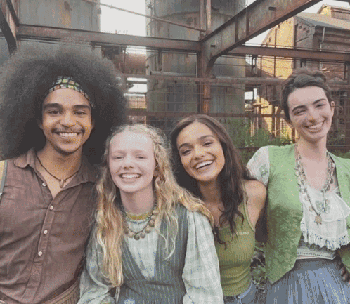 A Group Of People Posing For A Picture With One Of Them Wearing A Green Vest GIF