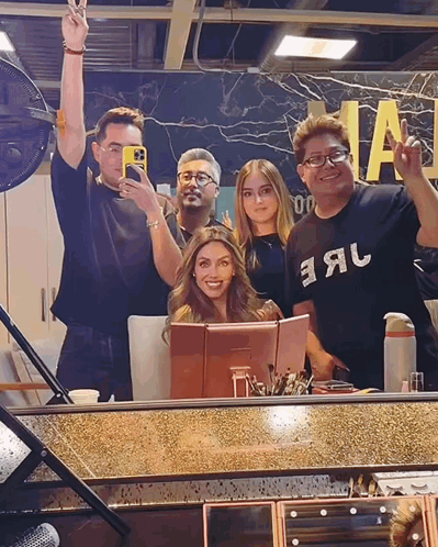 a group of people posing in front of a mirror with one wearing a shirt that says earl