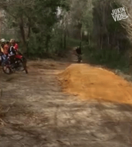 A Group Of People Riding Motorcycles Down A Dirt Road With The Words Jukin Video In The Corner GIF