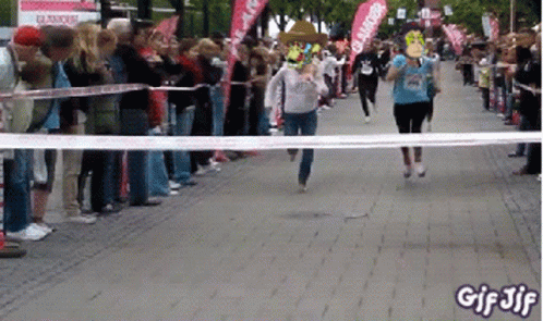 A Group Of People Running A Race With A Banner That Says Glamour GIF