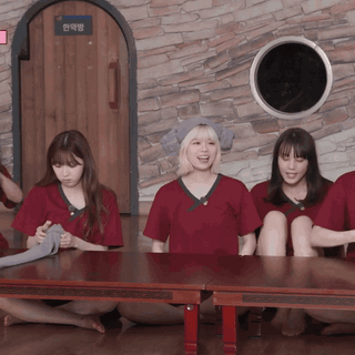A Group Of People Sitting Around A Table With A Sign On The Wall That Says ' A ' On It GIF