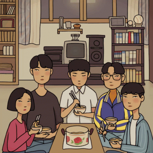 A Group Of People Sitting Around A Table With Bowls Of Food GIF