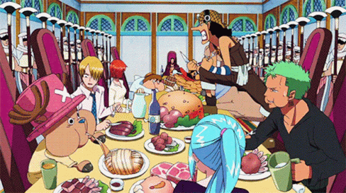 A Group Of People Sitting Around A Table With Plates Of Food GIF