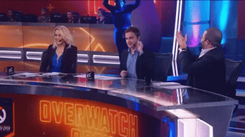 A Group Of People Sitting At A Table With Overwatch Written On The Top GIF