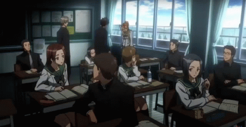 A Group Of People Sitting At Desks In A Classroom With A Bulletin Board In The Background GIF