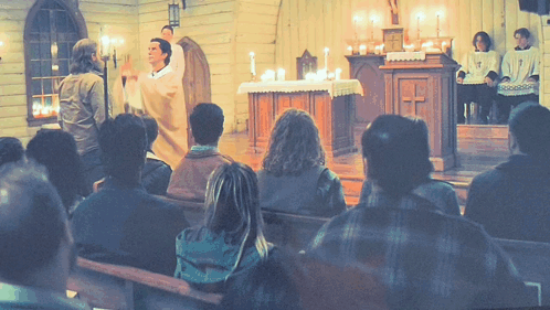 A Group Of People Sitting In A Church Watching A Priest GIF