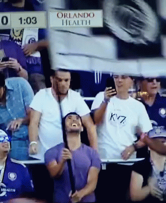 A Group Of People Sitting In A Stadium With A Sign That Says Orlando Health On It GIF