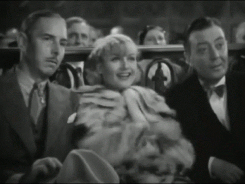 A Group Of People Sitting In A Theater Watching A Movie GIF