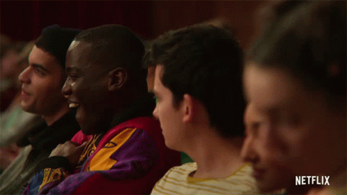 A Group Of People Sitting In A Theatre With A Netflix Logo On The Bottom GIF