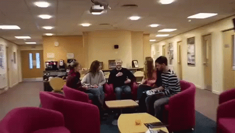 a group of people sitting in chairs in a hallway