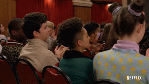 A Group Of People Sitting In Red Chairs With Netflix Written On The Bottom GIF