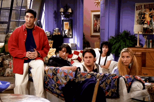 A Group Of People Sitting On A Couch In Front Of A Sign That Says Aux Bluttes GIF