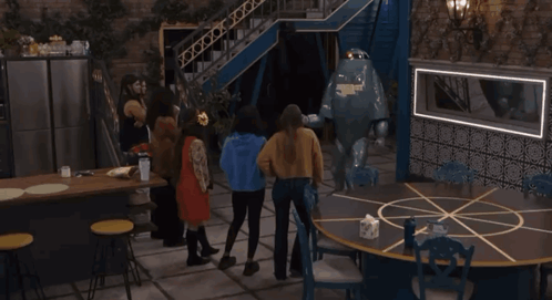 a group of people standing around a round table with a robot on it