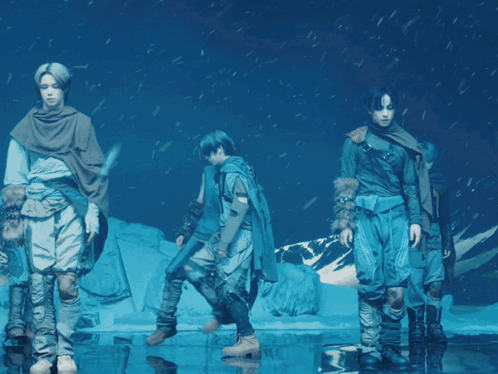 A Group Of People Standing In A Circle In Front Of A Snowy Mountain GIF