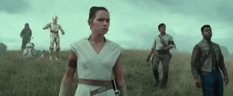 A Group Of People Standing In A Field With A C3po And Bb-8 In The Background GIF