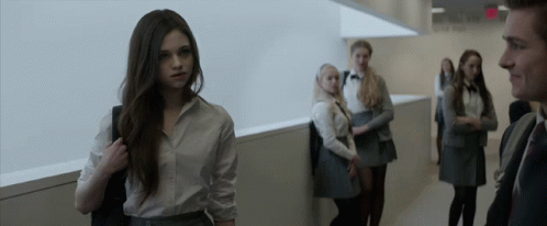 A Group Of People Standing In A Hallway With A Sign That Says Exit On It GIF