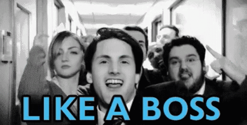 A Group Of People Standing In A Hallway With The Words Like A Boss Written On The Bottom GIF