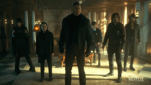 A Group Of People Standing In A Room With A Netflix Logo On The Bottom GIF