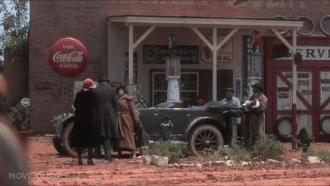 a group of people standing in front of a coca cola store