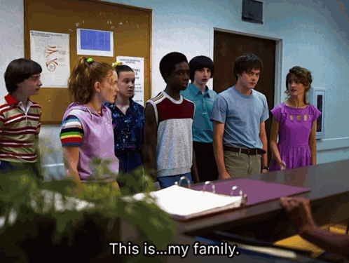 A Group Of People Standing In Front Of A Desk With The Words " This Is My Family " On The Bottom GIF